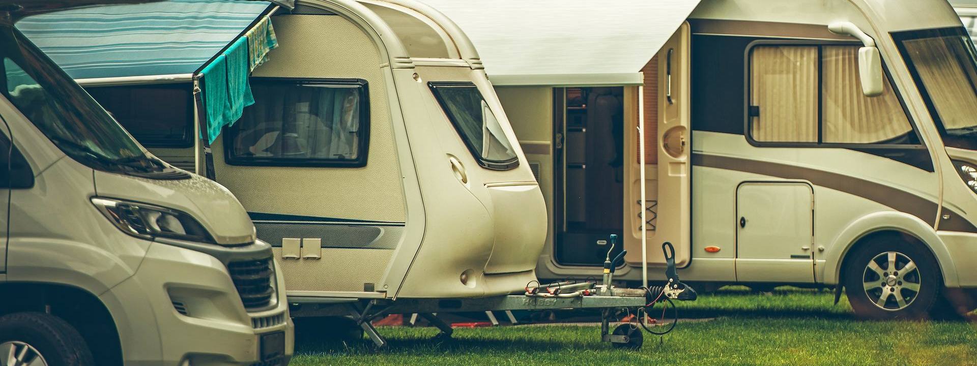 Motorhomes and a touring caravan with awnings, ready for a caravan valuation