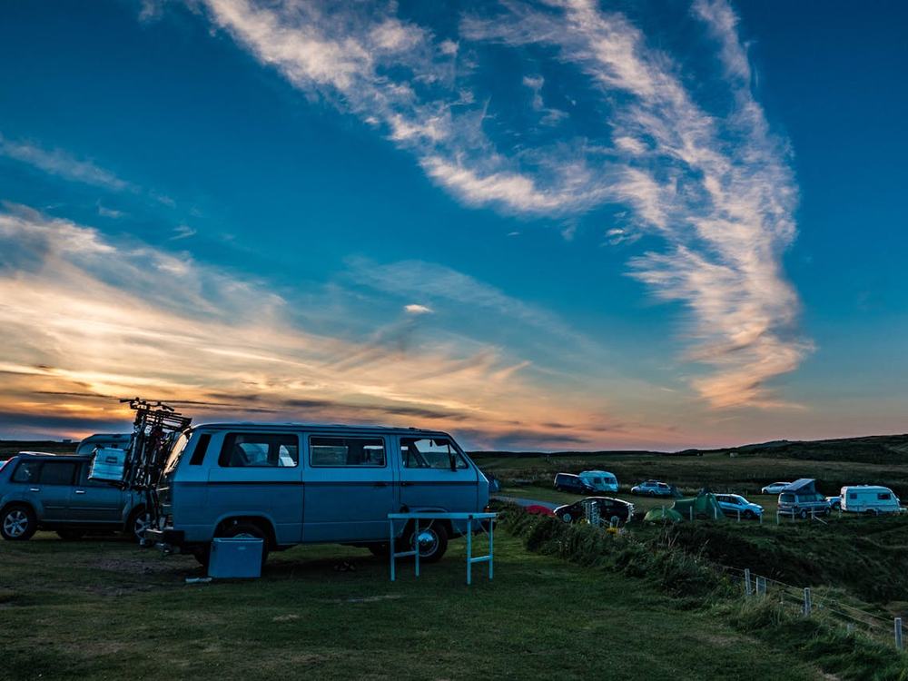 Campervan parked at a campsite at sunset